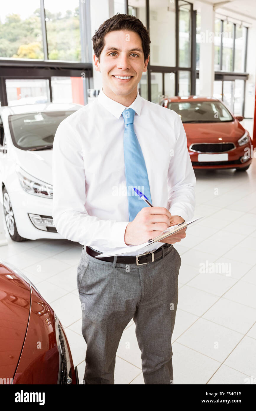 Smiling businessman writing on clipboard Stock Photo - Alamy