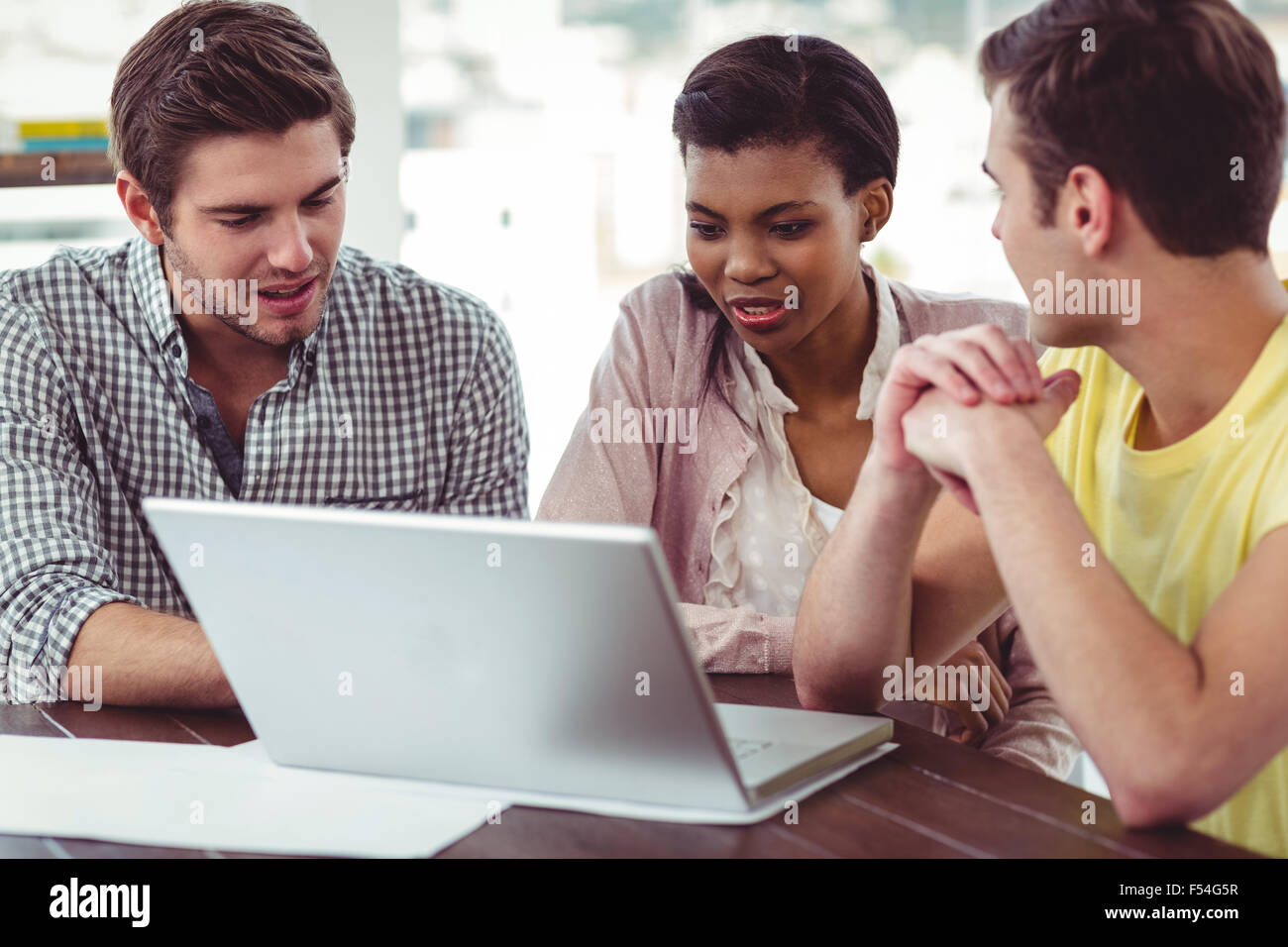 Creative team working together on a laptop Stock Photo - Alamy
