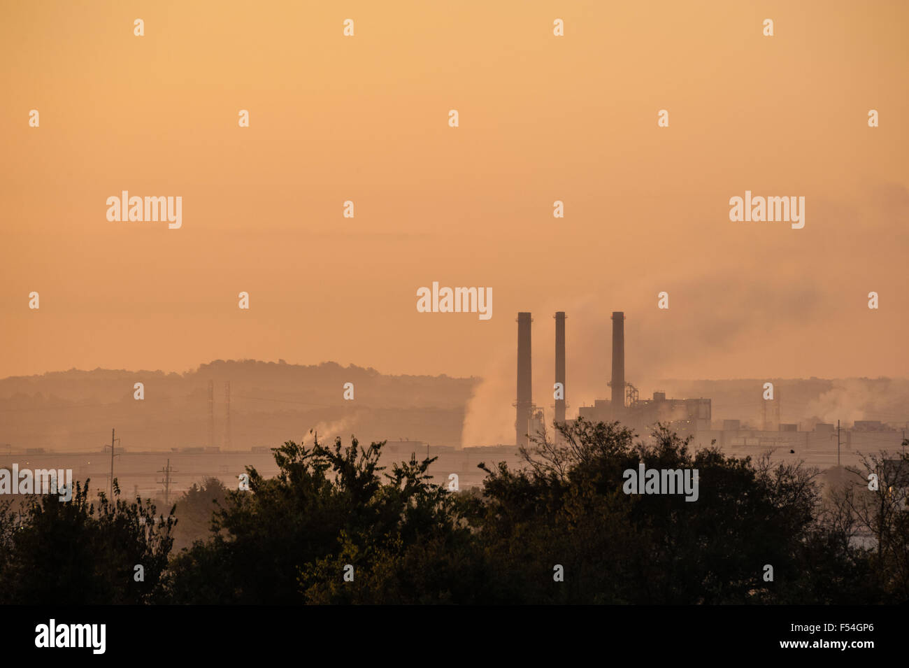 Smoke stacks of the OG+E Muskogee Power Plant rise against a foggy sky at daybreak in Fort Gibson, Oklahoma. (USA) Stock Photo