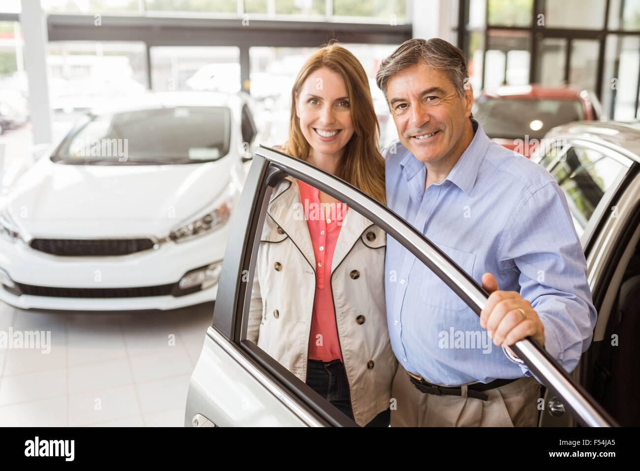 Smiling couple leaning on car Stock Photo