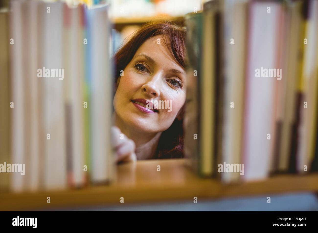 Mature student picking out book in library Stock Photo