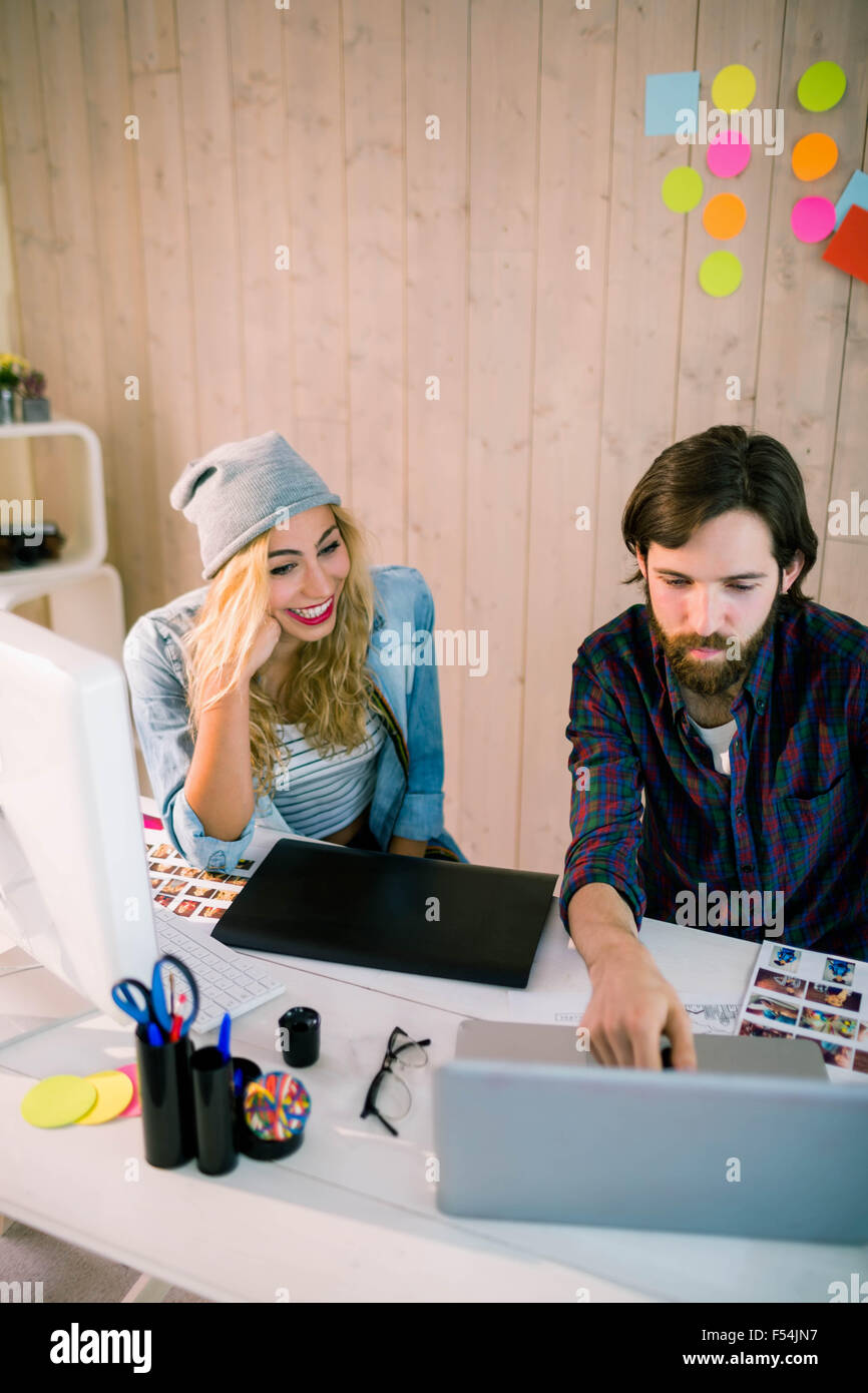 Creative team working at desk with laptop Stock Photo - Alamy