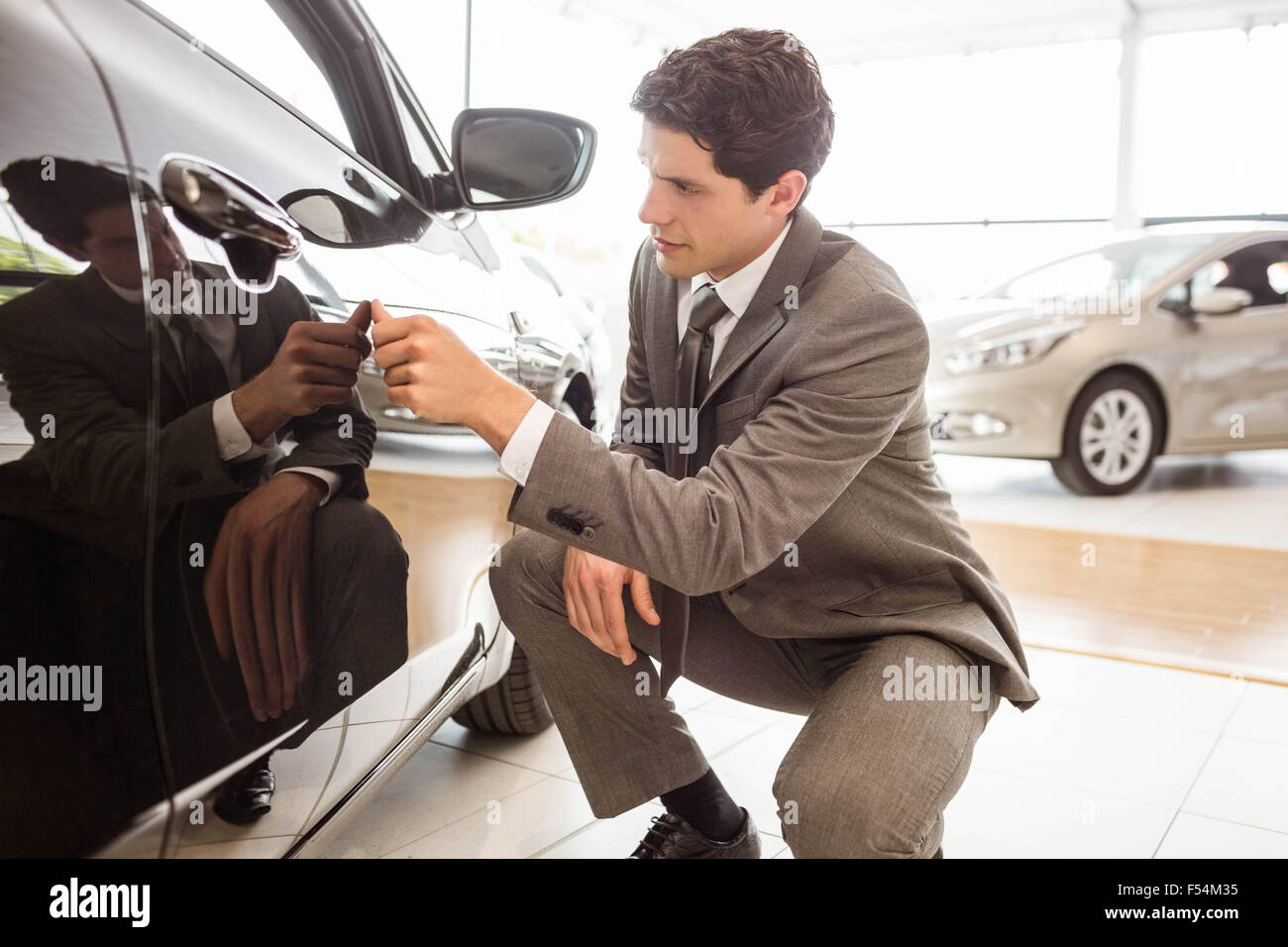 Focused businessman looking at the car body Stock Photo