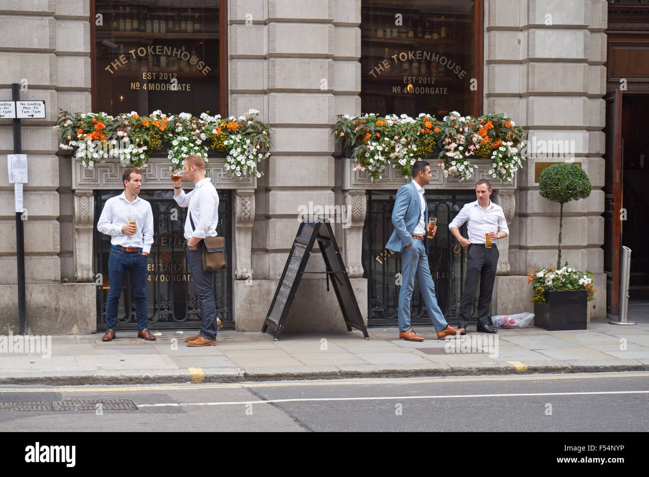 City workers drinking beer outside pub in London England United Kingdom UK Stock Photo