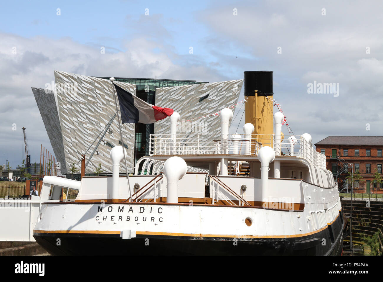 The SS Nomadic in Hamilton Dock, Belfast with The Titanic Visitors' Centre in the background. Stock Photo