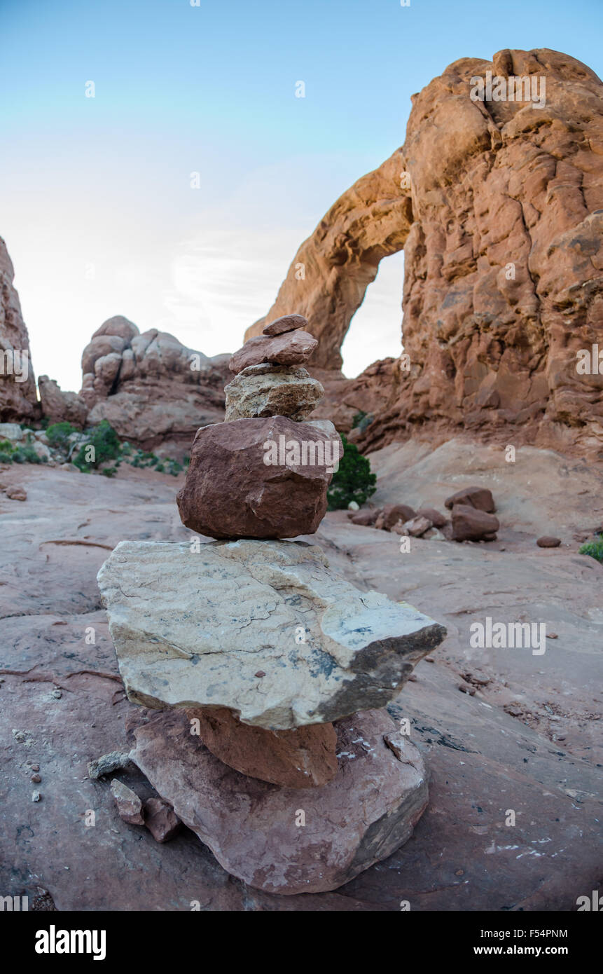 A small rock cairn marks the trail around an arch in a Utah park Stock Photo
