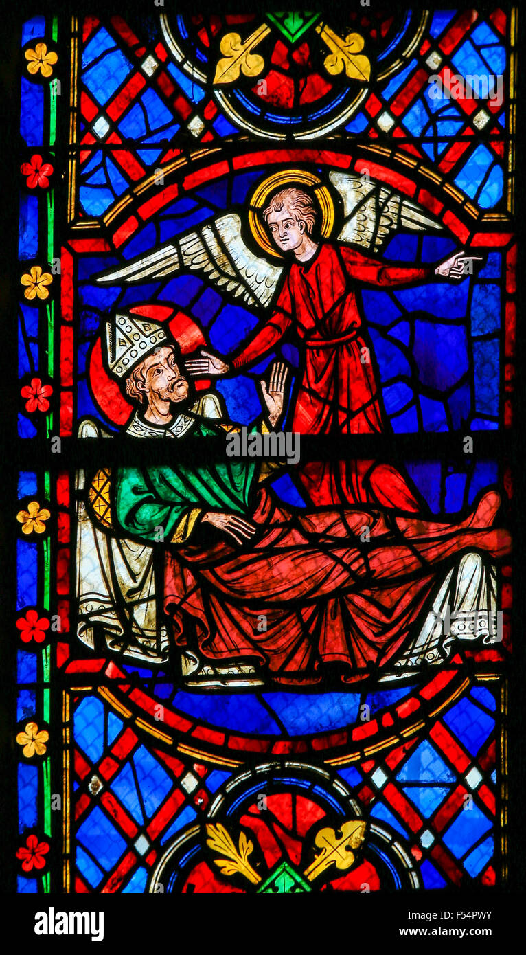 Stained glass window depicting a Saint on his deathbed, called by an Angel, in the Cathedral of Tours, France. Stock Photo