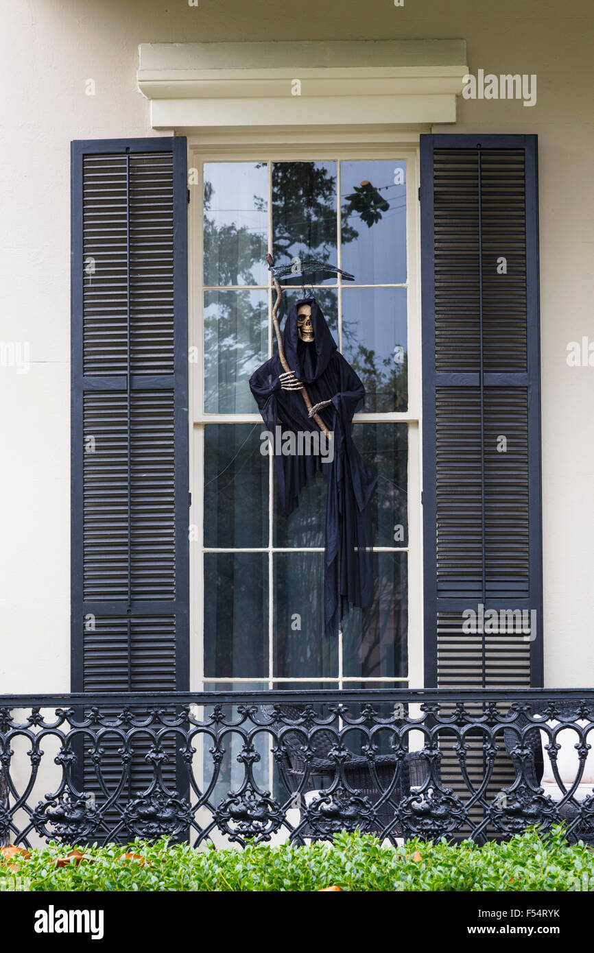 Scary Halloween voodoo grim reaper ghost character at mansion house with wrought iron in the Garden District of New Orleans, USA Stock Photo
