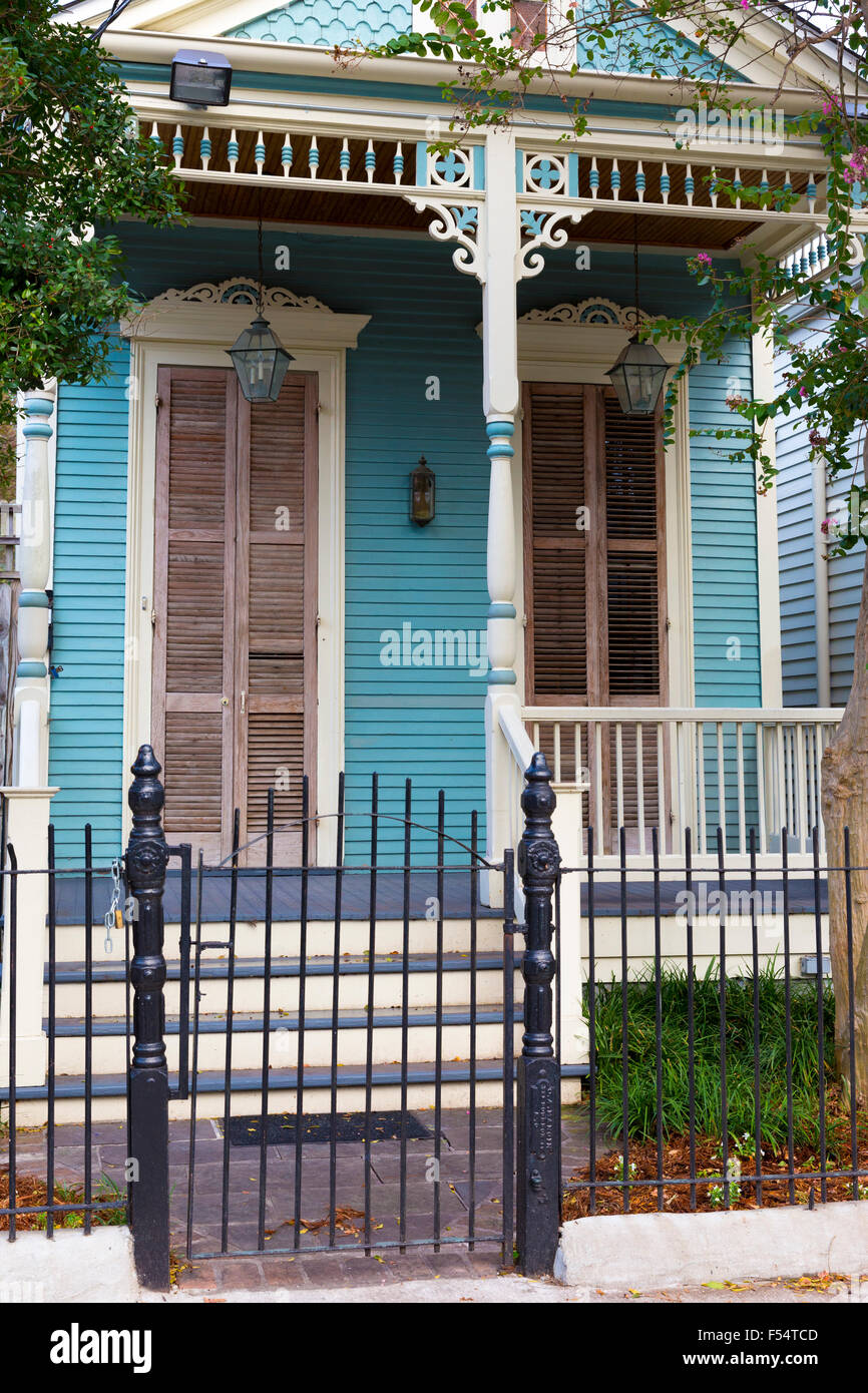 Traditional bright clapboard creole cottage home with front stoop in