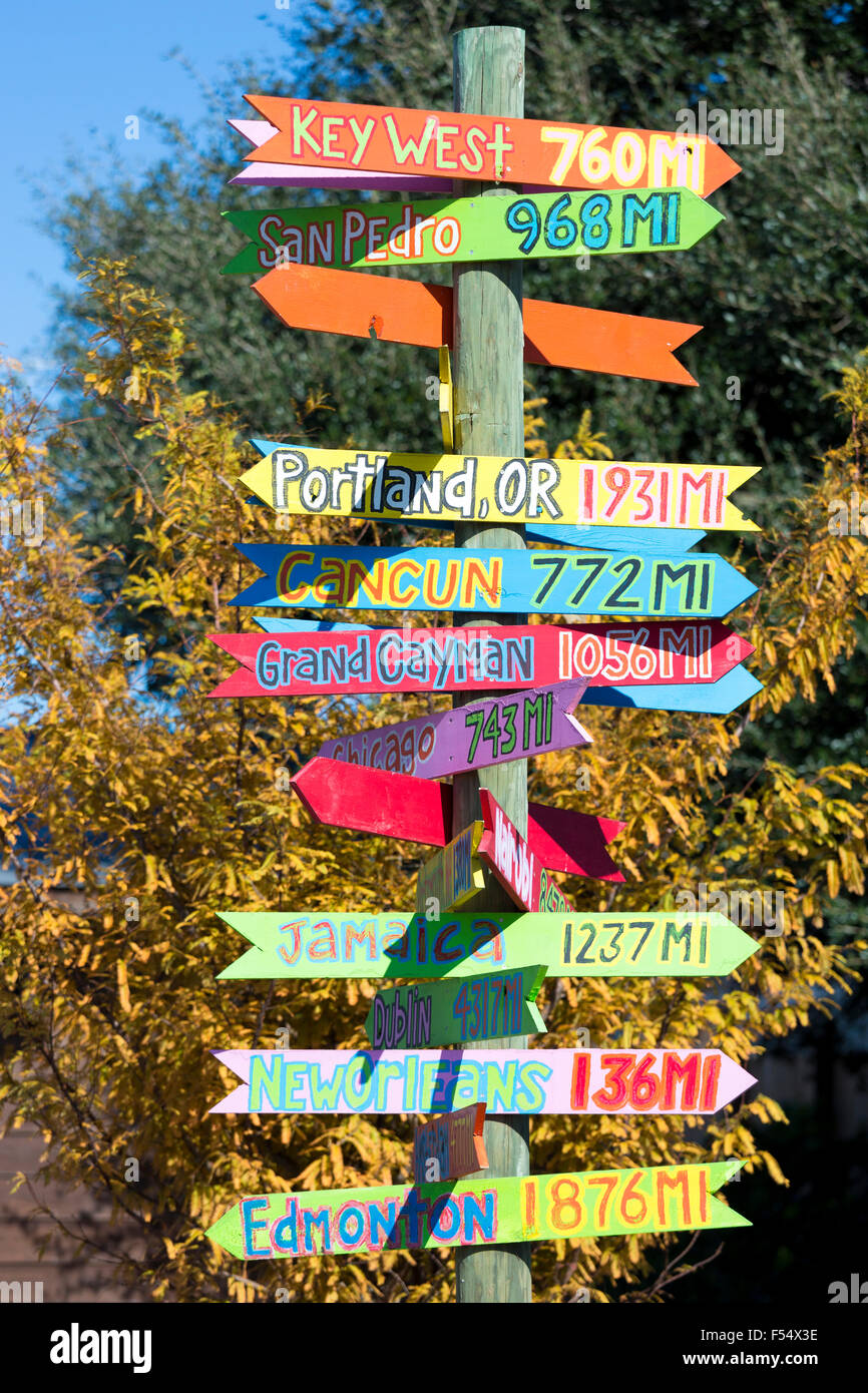 Bright color jokey fun direction signpost with distances for far flung places in Natchez, Mississippi USA Stock Photo