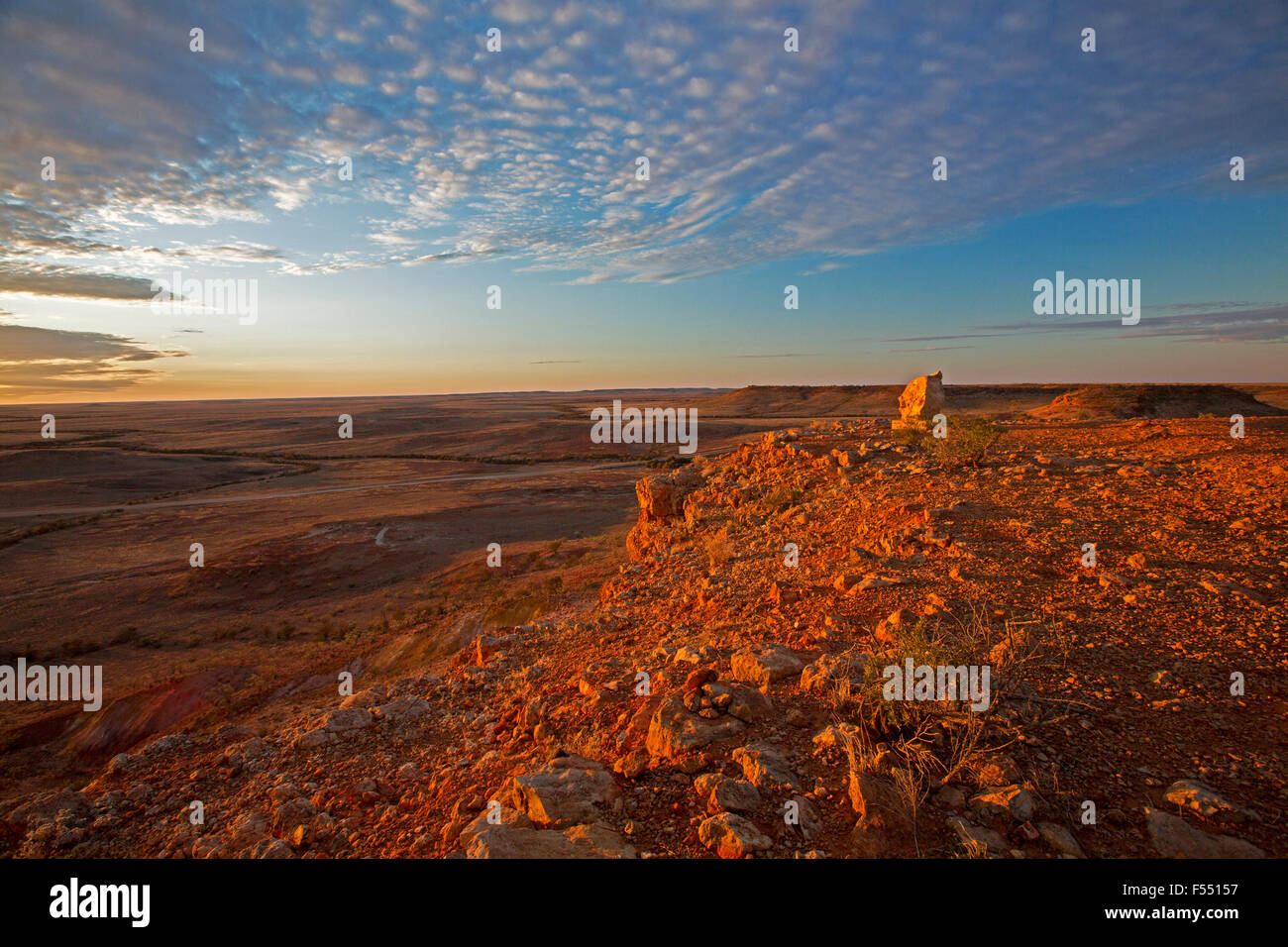 Stunning Australian outback landscape from hilltop lookout at sunset, rocky mesas on vast barren treeless plains stretching to far horizon Stock Photo