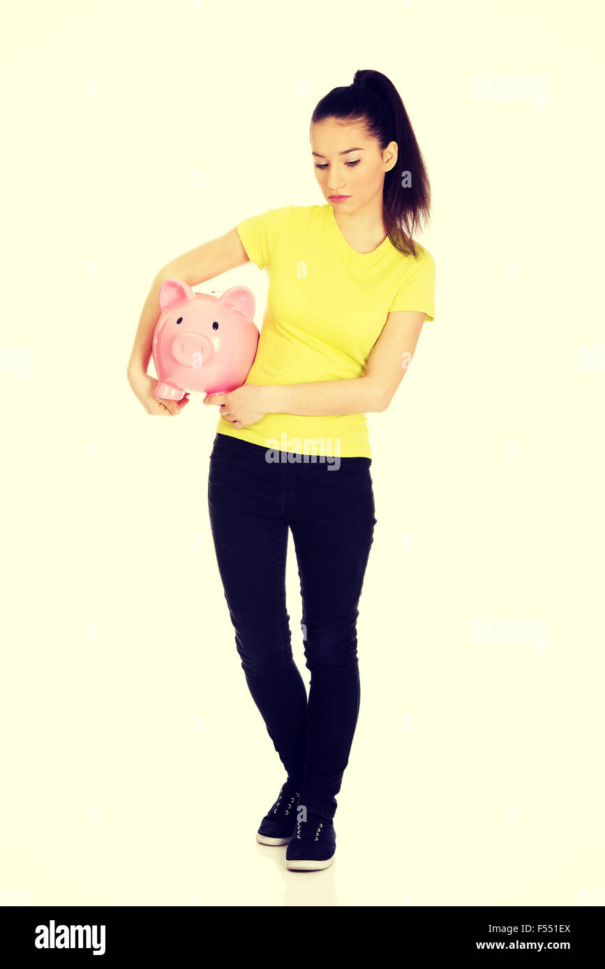 Unhappy woman holding piggybank. Stock Photo