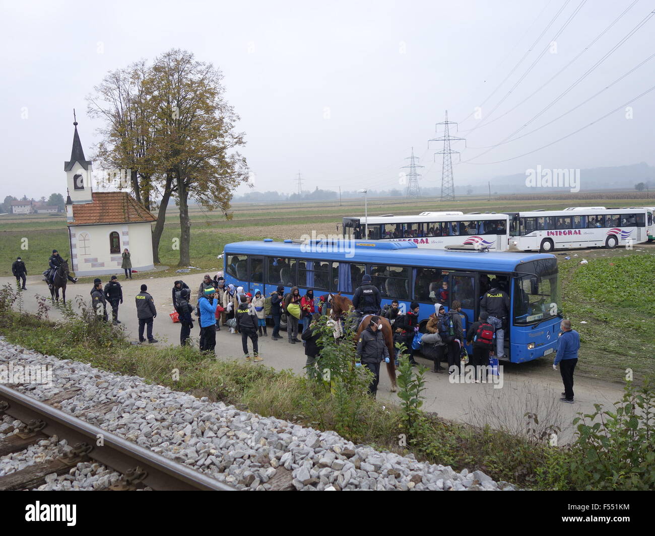 Rigonce. 27th Oct, 2015. Refugees coming from Croatia by train queue to get on buses to be transfered to the refugee centre inland Slovenia in Rigonce, a tiny Slovenian border town with Croatia on on Oct. 27, 2015. By midday on Tuesday over 5,800 refugees had entered Slovenia, bringing the total to almost 86,500 so far this year, according to the STA latest report. Credit:  Wang Yaxiong/Xinhua/Alamy Live News Stock Photo