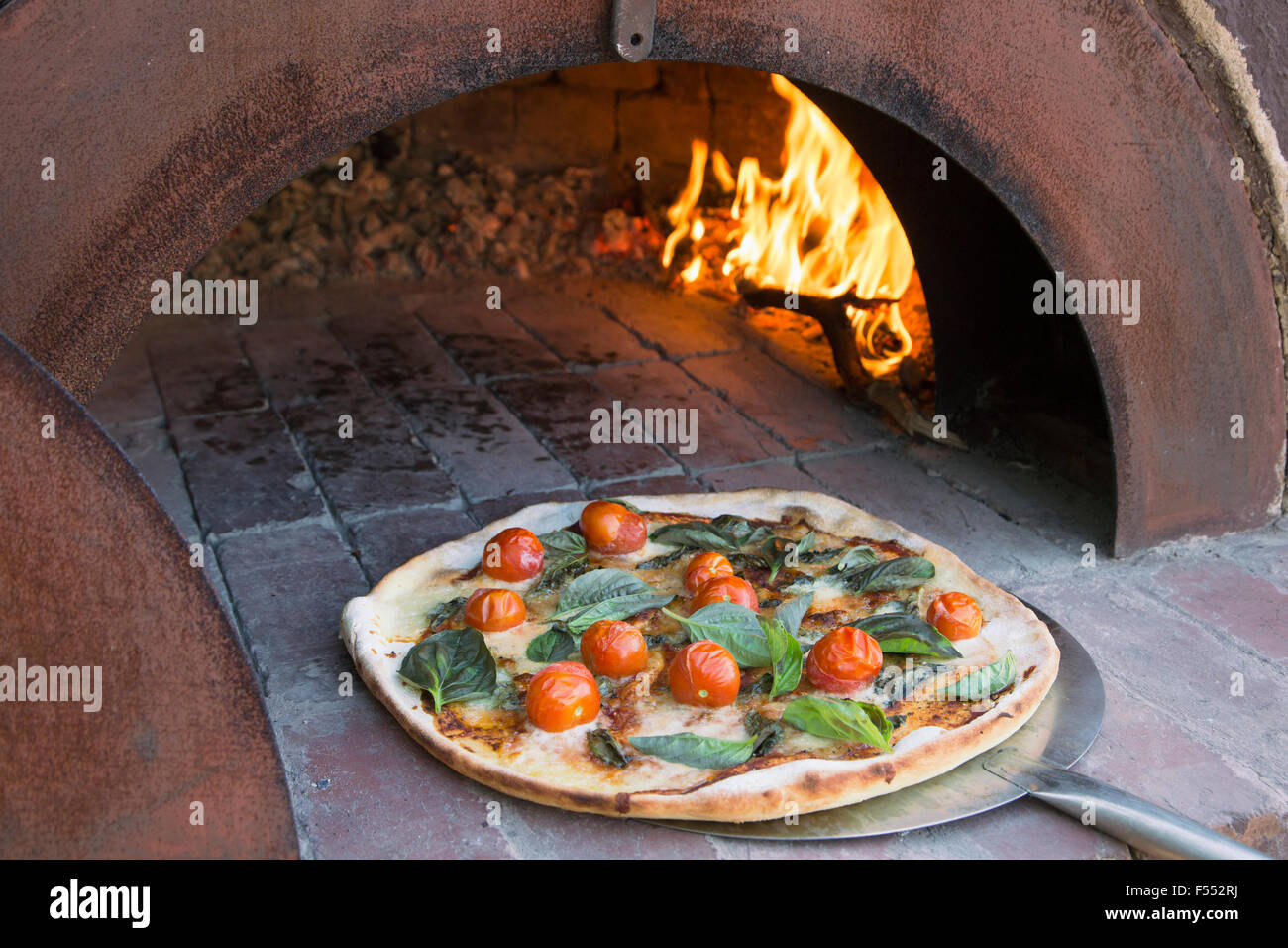 Fresh pizza on peel in traditional oven Stock Photo Alamy