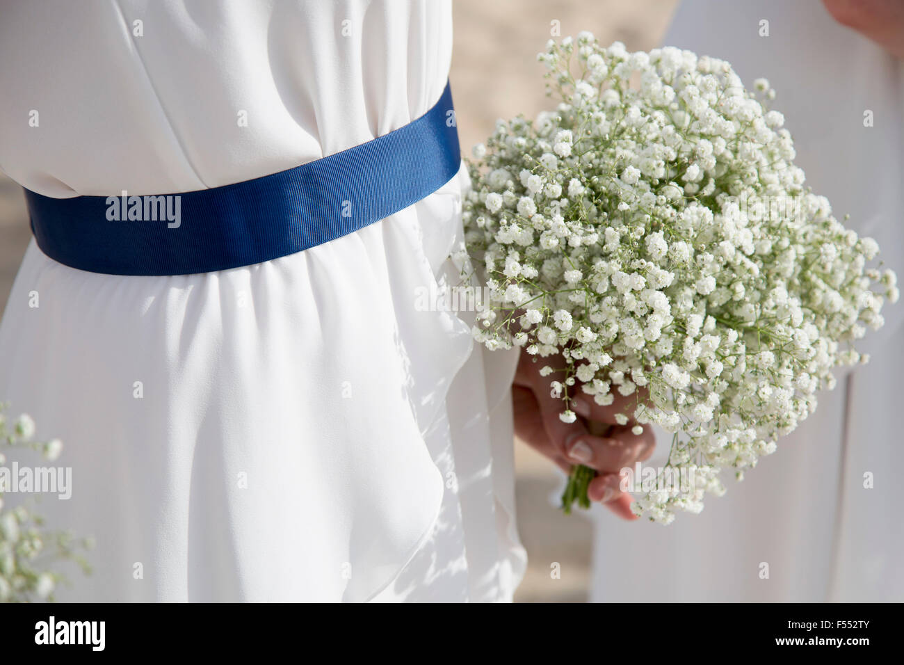 Midsection of bride holding flowers outdoors Stock Photo