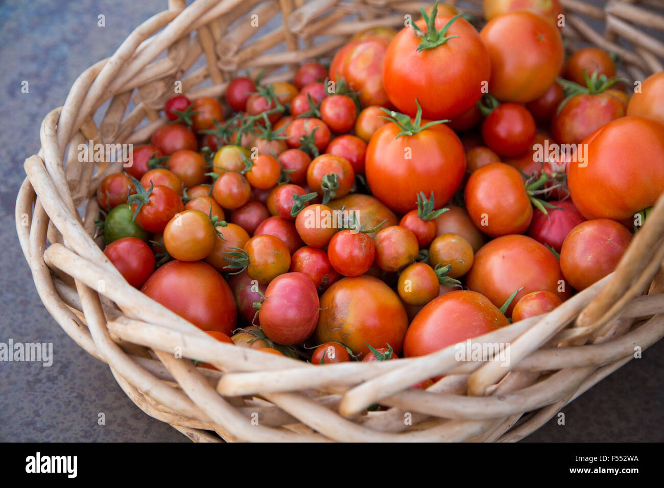 High angle view of fresh tomatoes in wicker basket Stock Photo - Alamy
