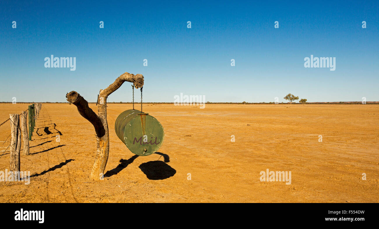 Panoramic view of Australian outback landscape with mail box on vast treeless plains stretching to horizon & blue sky during drought Stock Photo