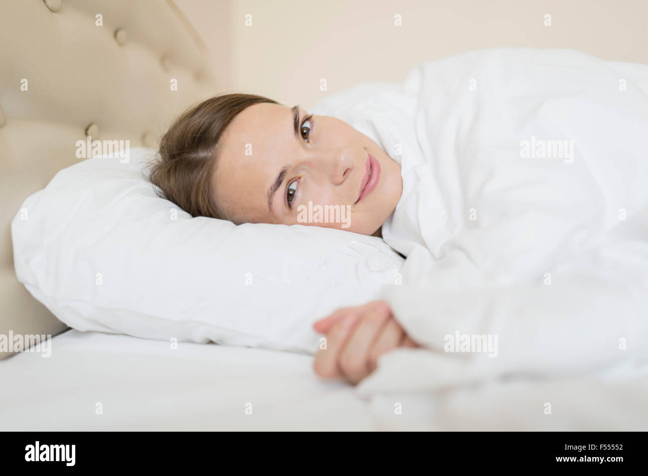 Portrait of beautiful woman relaxing in bed at home Stock Photo