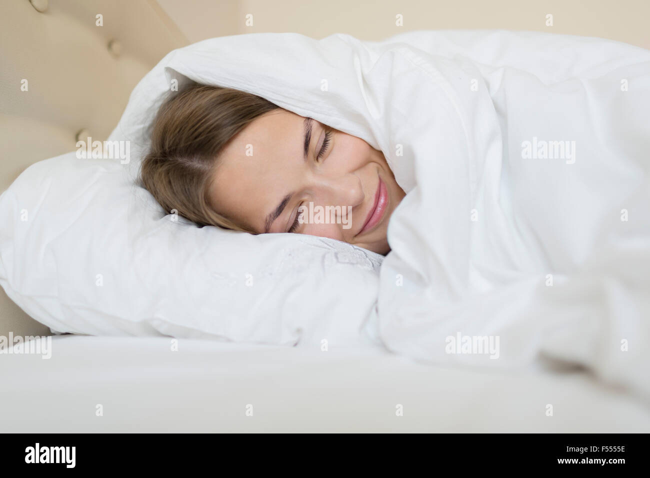 Happy woman sleeping in bed at home Stock Photo