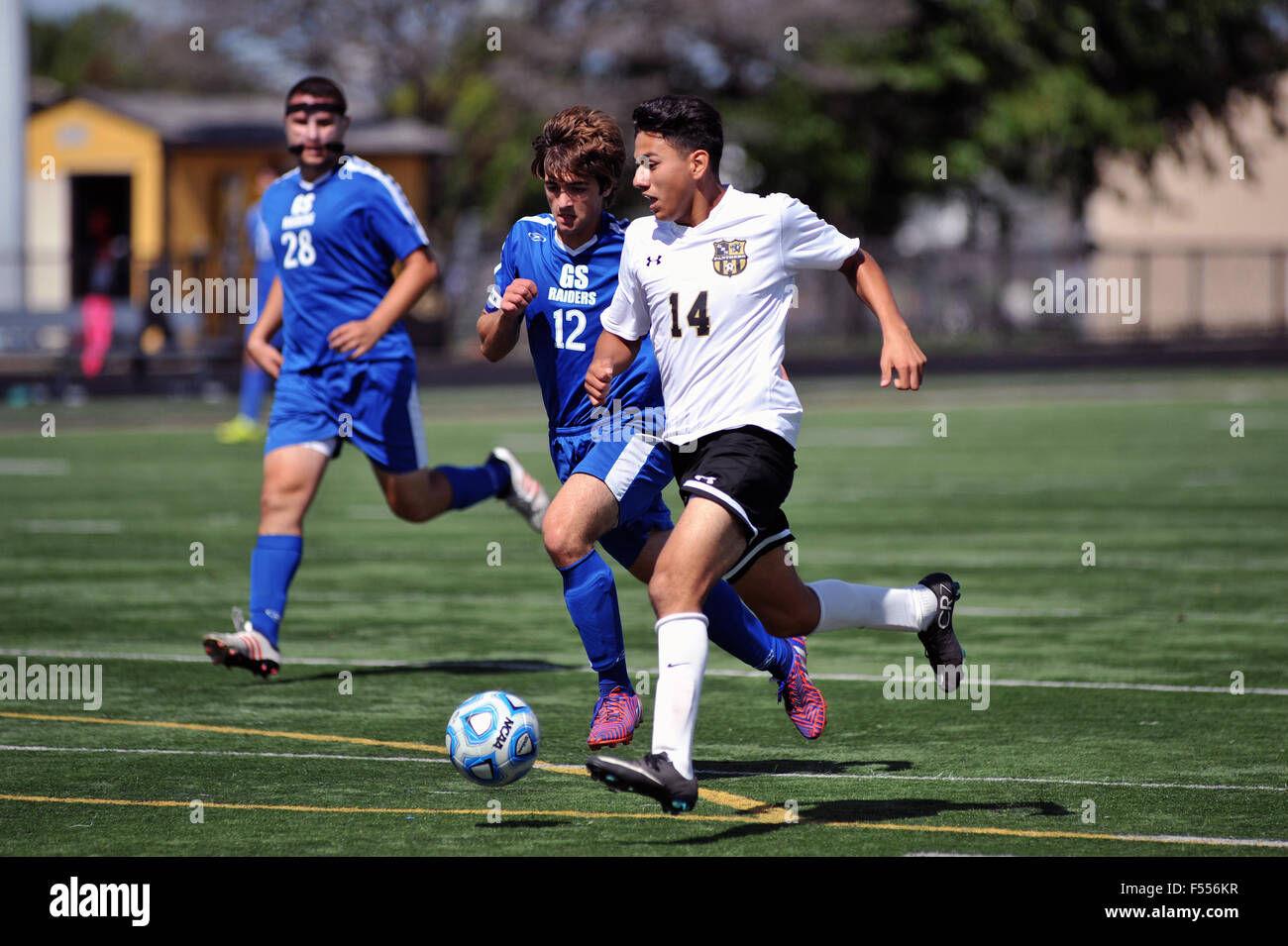 A high school striker dribbles the ball past midfield as he attempts to set up a scoring opportunity for his team. USA. Stock Photo