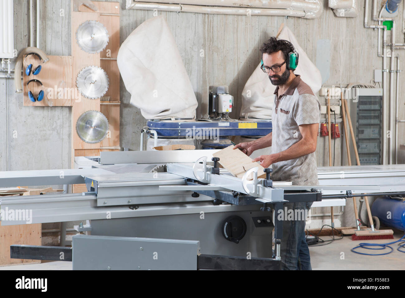 Male carpenter using a sliding table saw in workshop Stock Photo