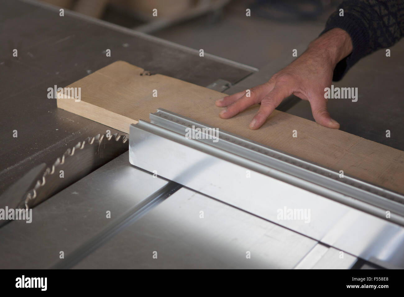 Cropped image of carpenter using sliding table saw in workshop Stock Photo