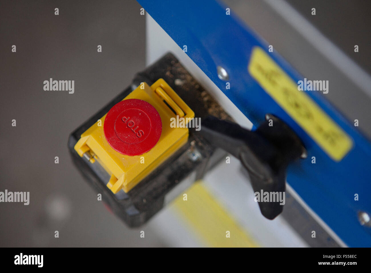 Close-up, high angle view of stop button of sliding table saw in workshop Stock Photo