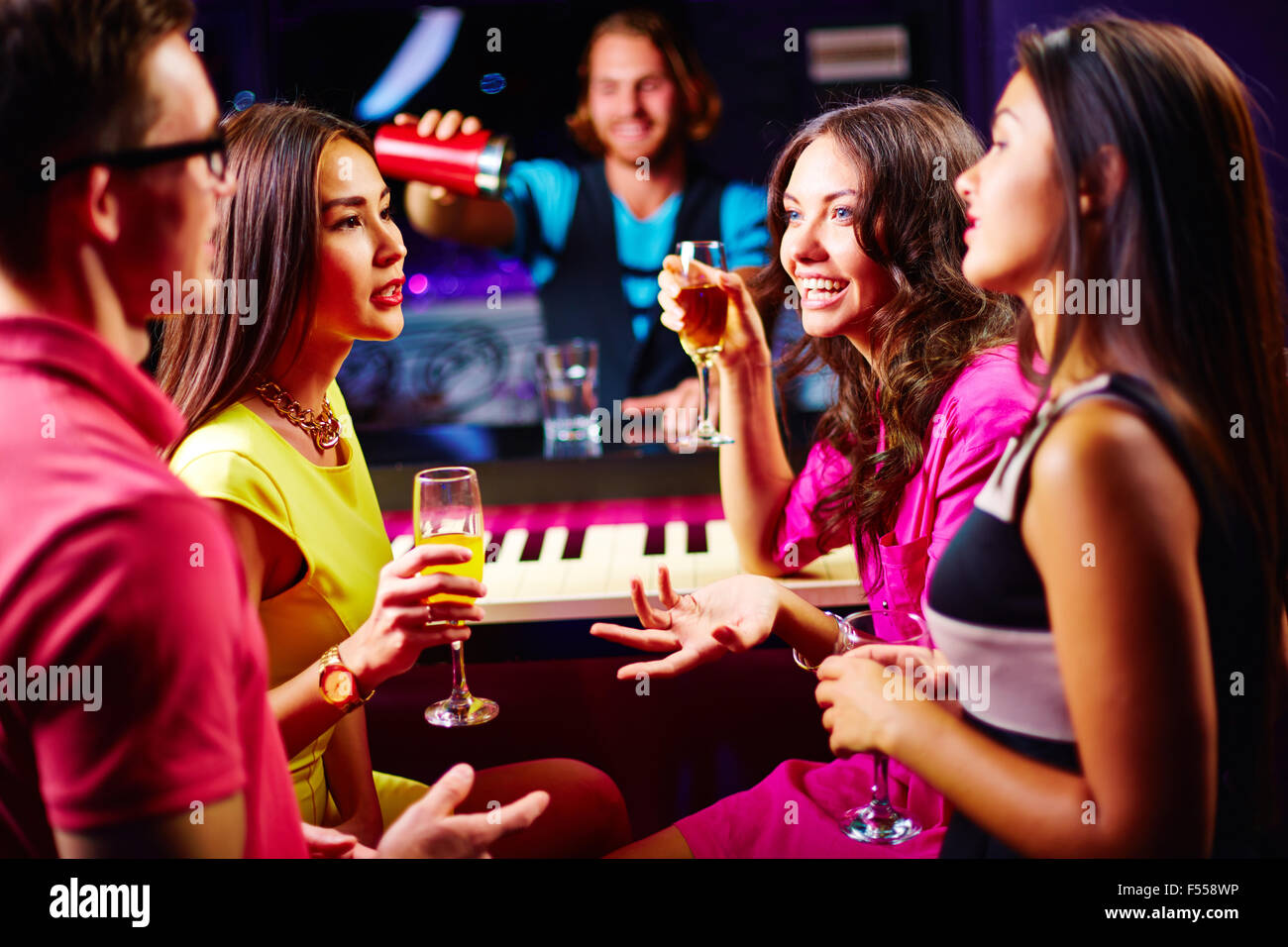 Young friends talking at party while drinking champagne Stock Photo