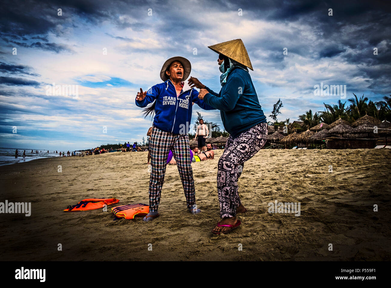 Two women fight on An Bang beach, Vietnam over a pitch to rent out rubber rings. Stock Photo
