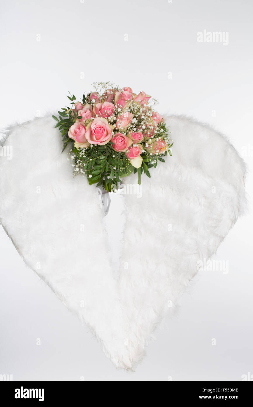 Flower bouquet and angel wings against white background Stock Photo