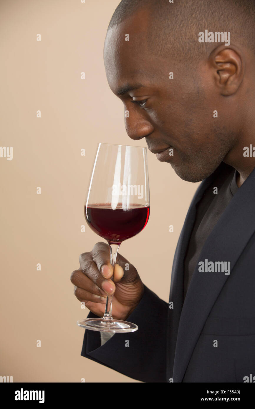 Man smelling red wine against colored background Stock Photo - Alamy