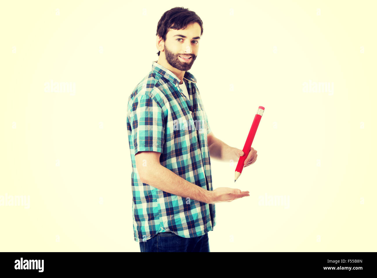 Young man writing with big red pencil. Stock Photo