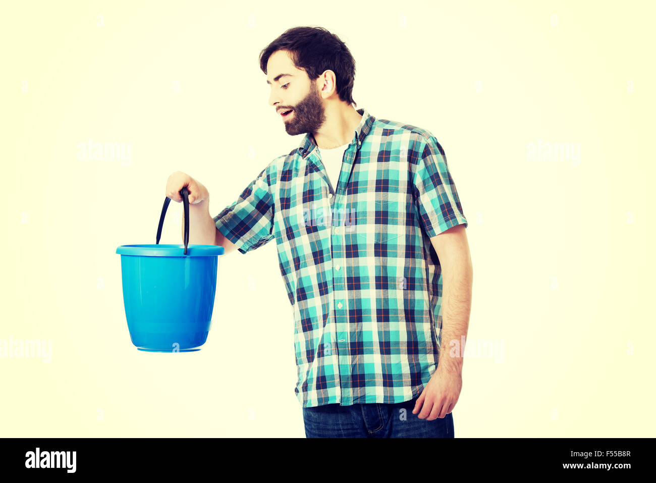 Handsome man looking into plastic bucket. Stock Photo