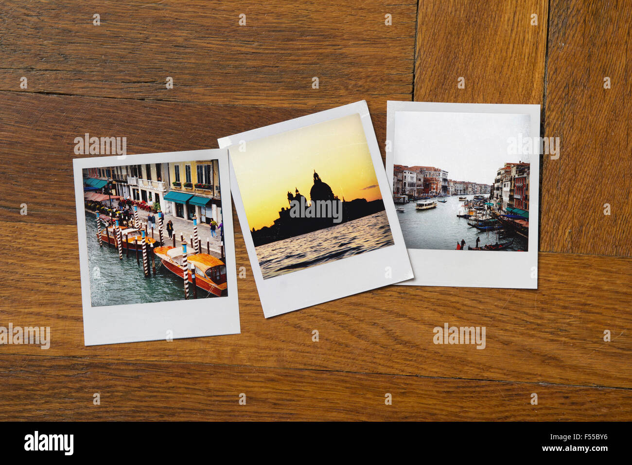 Instant print photographs of famous places on wooden table Stock Photo