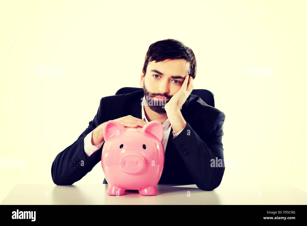 Young man worried piggy bank hi-res stock photography and images - Alamy