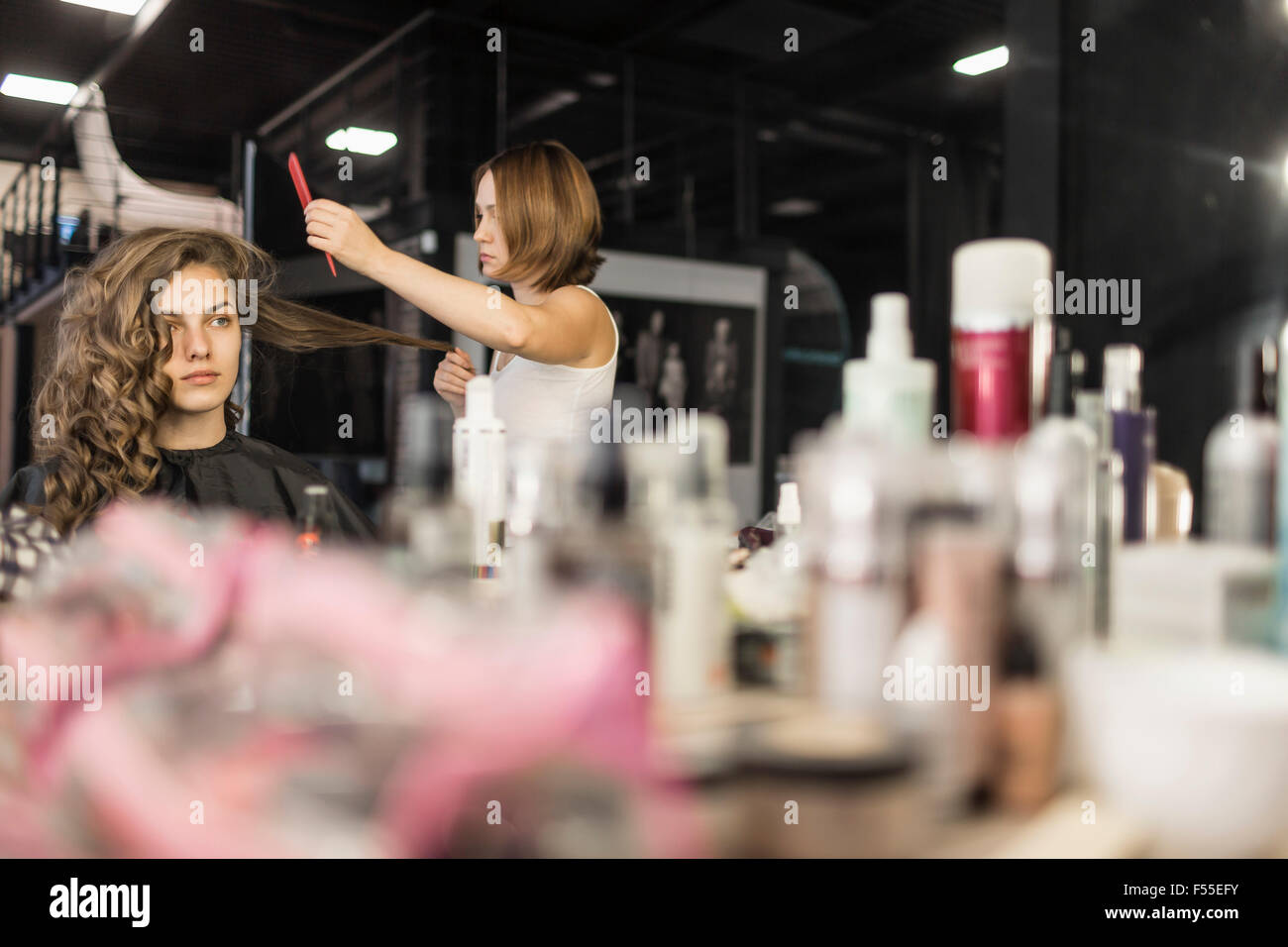 Hairdresser combing fashion model's hair Stock Photo