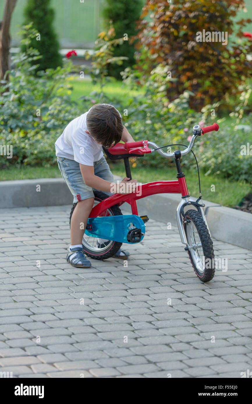 Boy adjusting bicycle seat Stock Photo Alamy