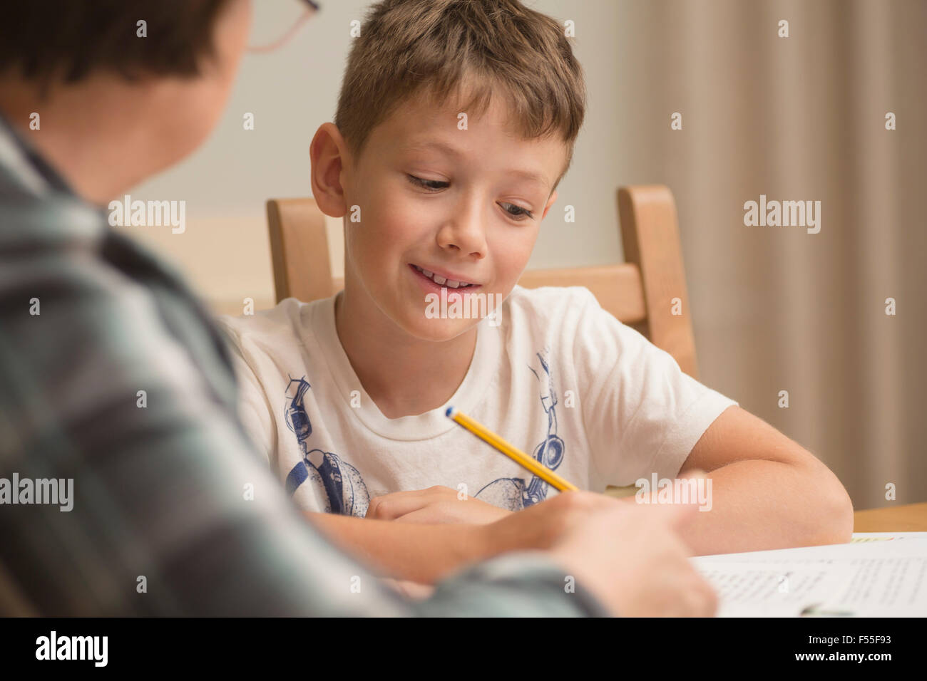 Grandmother teaching boy on table at home Stock Photo