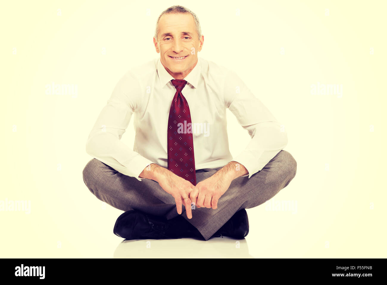 Businessman sitting crosslegged on the floor Stock Photo Alamy