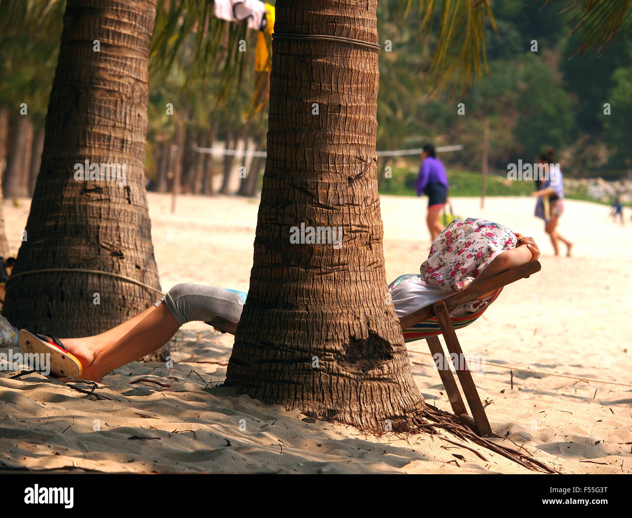 Woman at beautiful beach with chaise-lounges Stock Photo
