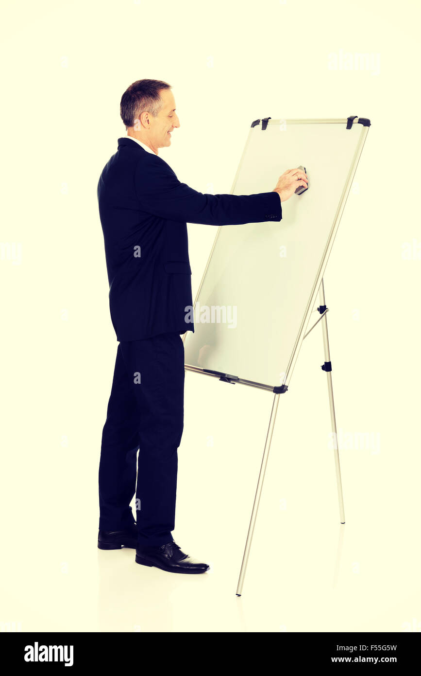 Male executive cleaning a flip chart Stock Photo