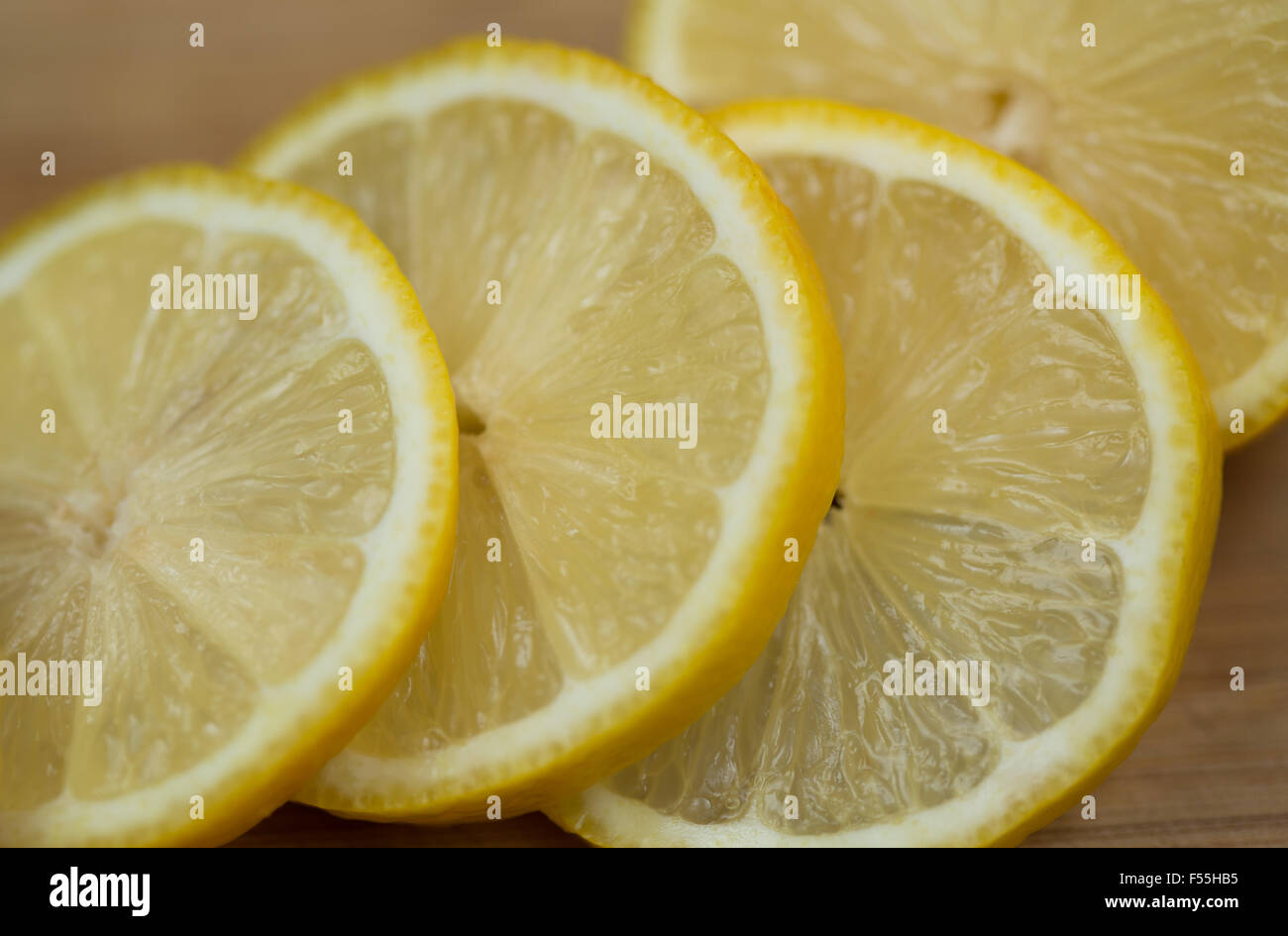 A fresh lemon sliced on a wooden chopping board. Stock Photo
