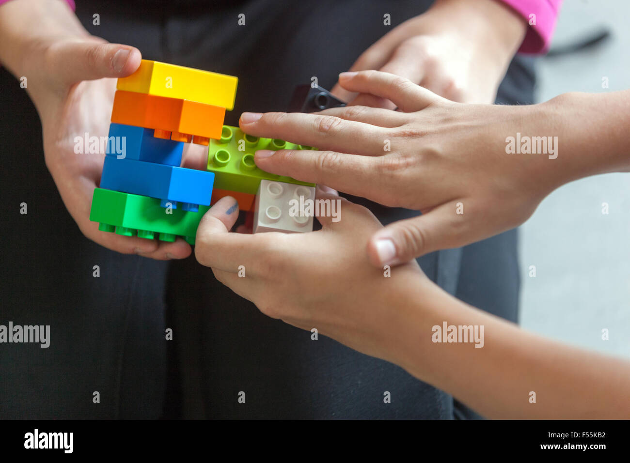 Plastic cubes in the hands of a child's game that develops creativity and imagination, lego bricks Children hands play with colorful lego blocks Stock Photo