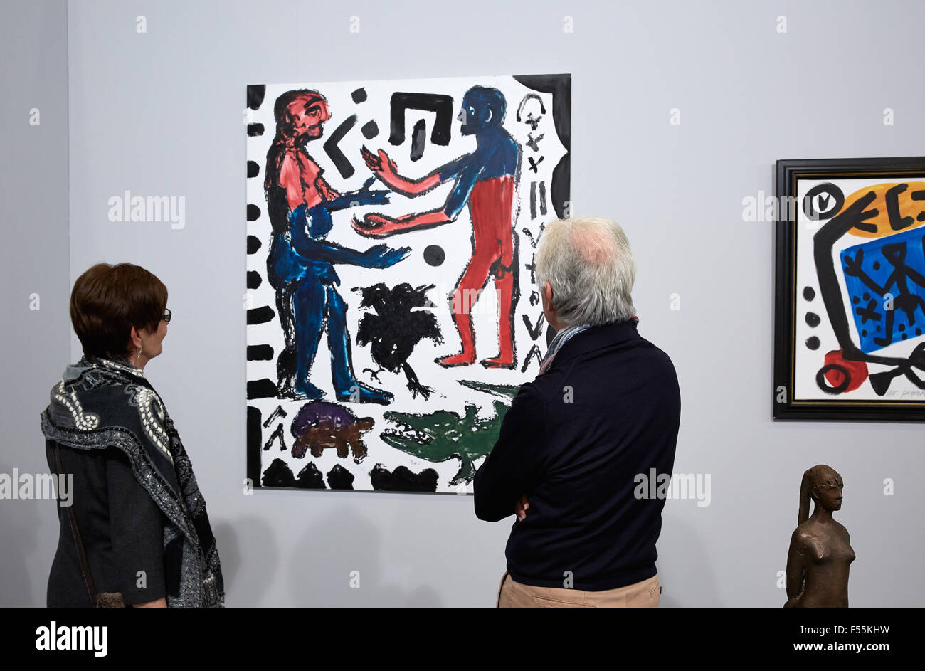 01.02.2015, Frankfurt am Main, Hesse, Germany - Visitors to the Art Fair Frankfurt 15 consider the painting repainting humans and animals by AR Penck at the booth of the gallery Kronsbein from Munich. 00R150201D057CAROEX.JPG - NOT for SALE in G E R M A N Y, A U S T R I A, S W I T Z E R L A N D [MODEL RELEASE: NO, PROPERTY RELEASE: NO (c) caro photo agency / Ruffer, http://www.caro-images.pl, info@carofoto.pl - In case of using the picture for non-journalistic purposes, please contact the agency - the picture is subject to royalty!] Stock Photo