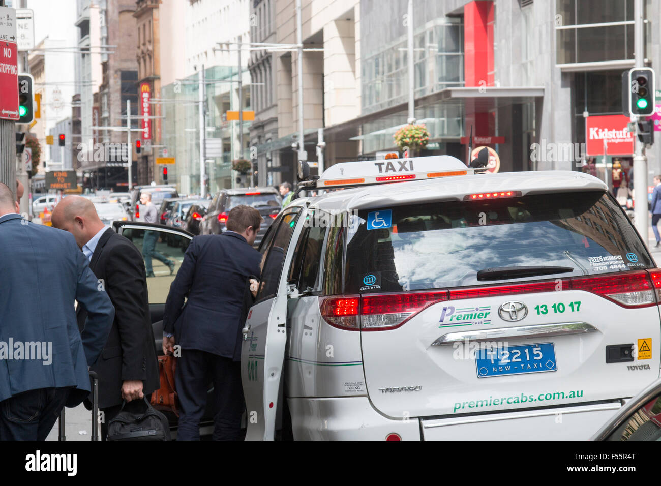 australian taxi in george street Sydney with business men departing having paid their fare,Sydney,Australia Stock Photo