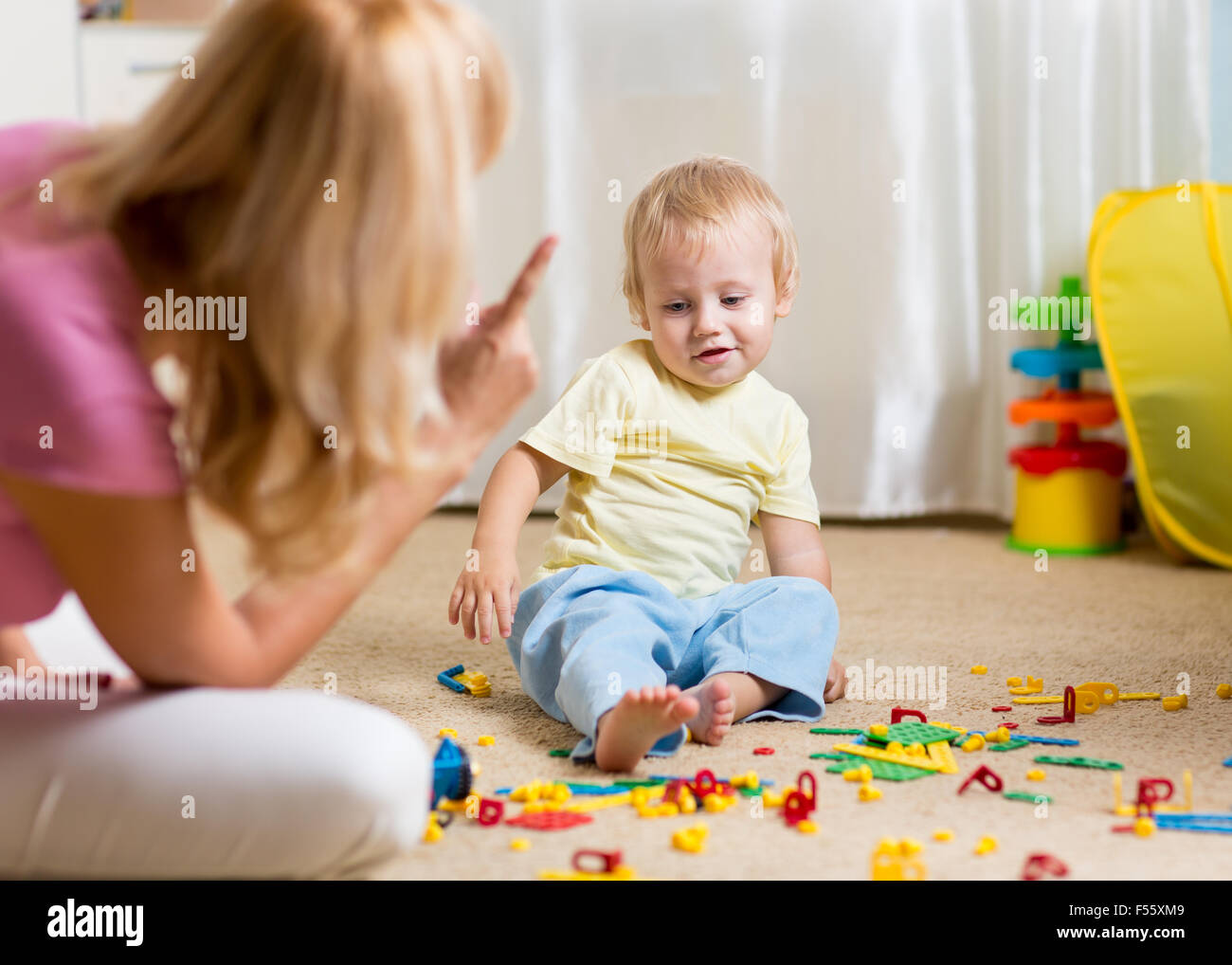 Mother berating her little child in jest at home Stock Photo
