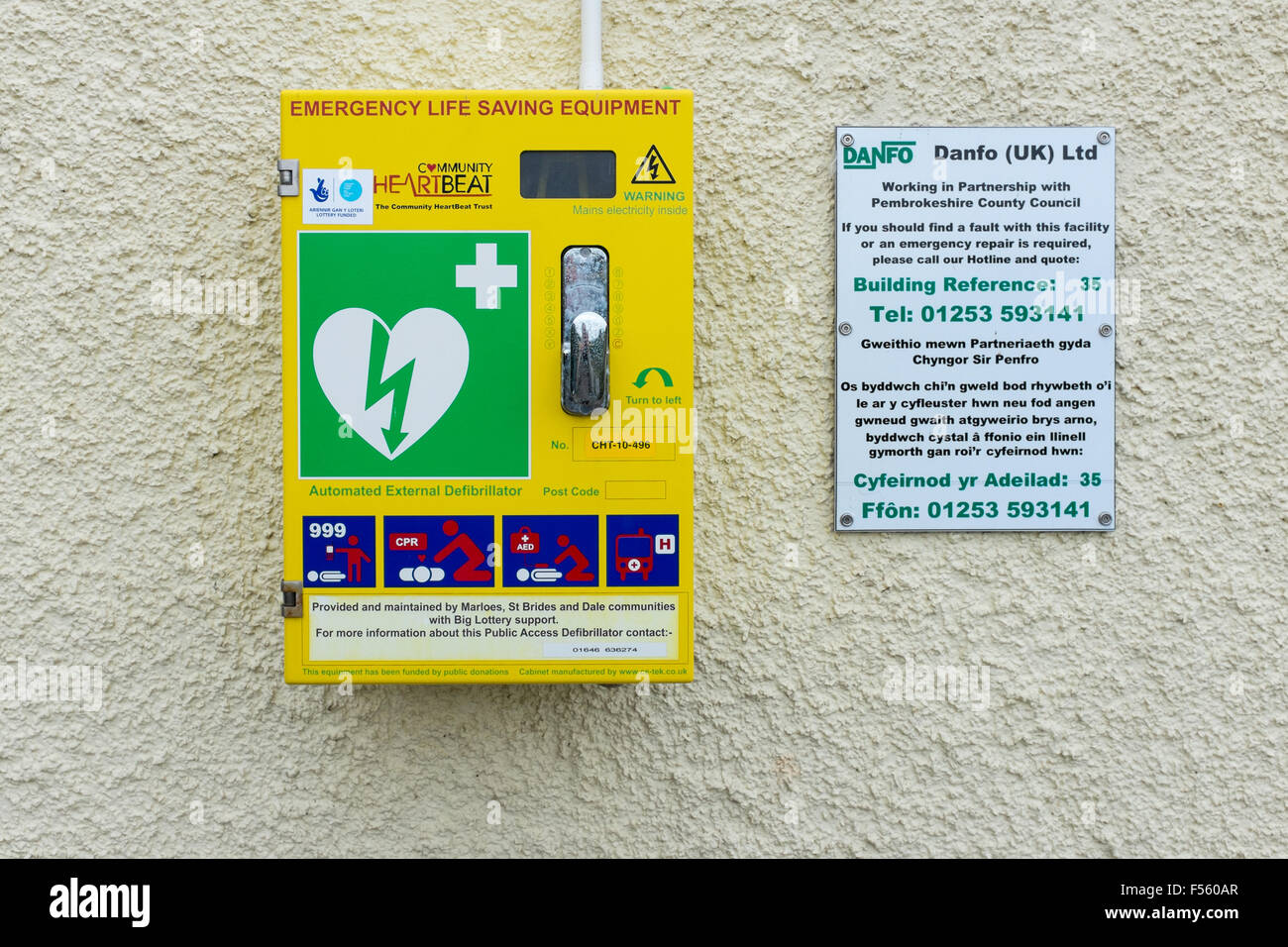 Emergency life saving equipment including a defibrillator mounted on a wall on the Pembrokeshire Coast Path National Trail Stock Photo