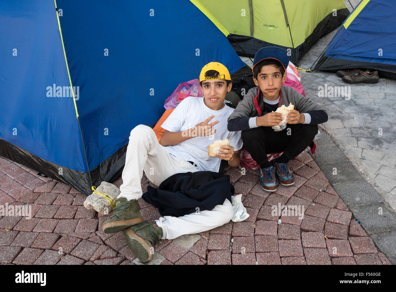 Two unidentified boys from Syria eat a sandwich outside their tent on October 14, 2015 in Kos island, Greece. Stock Photo