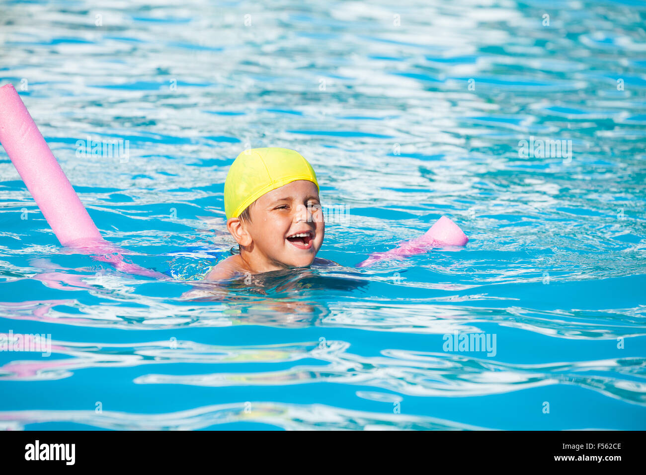 Laughing boy learns how to swim with pool noodle Stock Photo Alamy