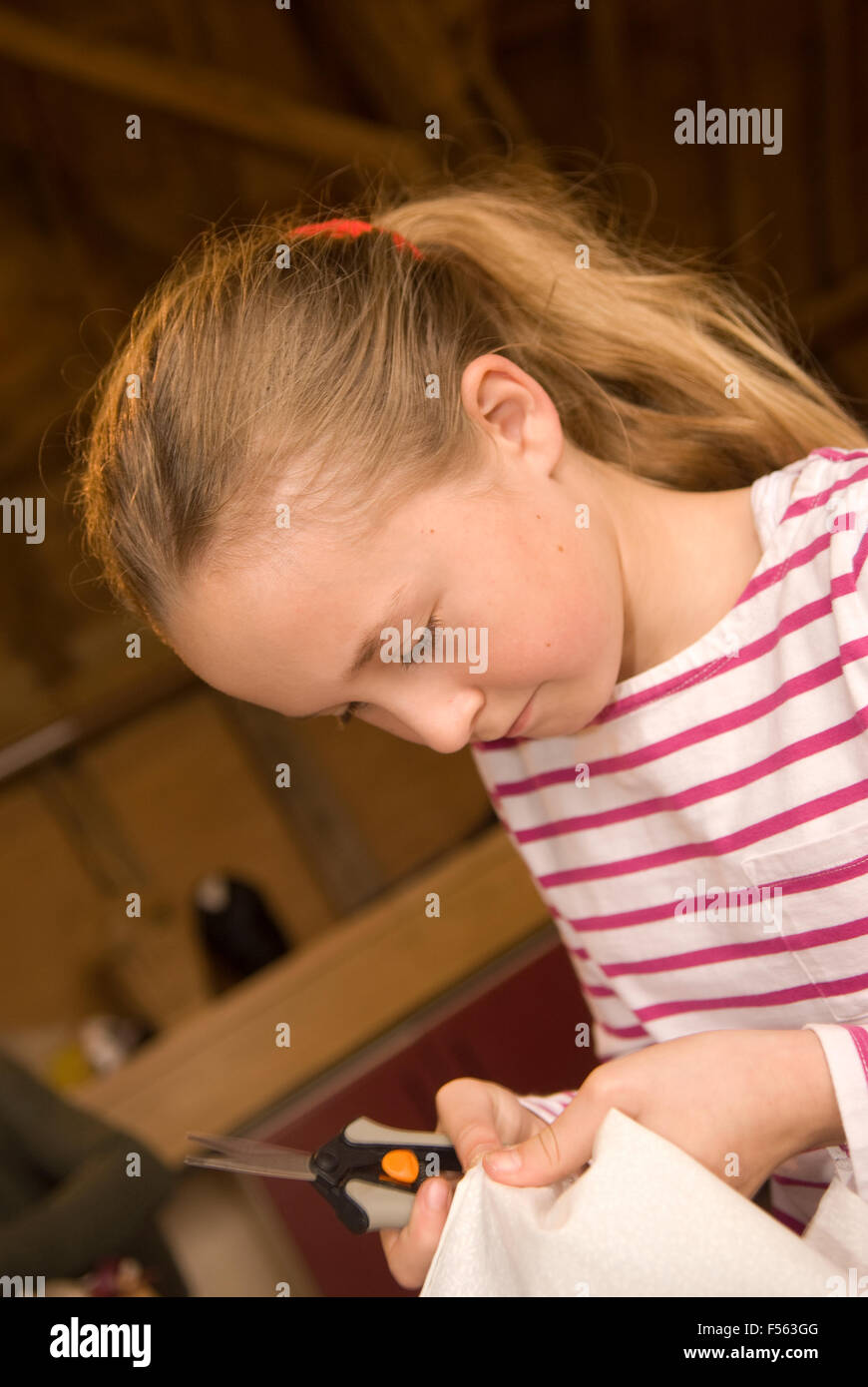 10 year old girl learning how to unpick stitching during a mother & daughter sewing day, Selborne, near Alton, Hampshire, UK. Stock Photo